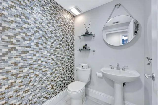 a bathroom with a sink a toilet and mirror