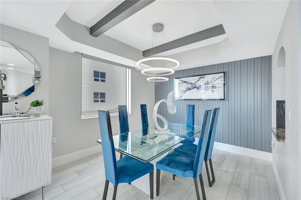 2104 West First Street, Unit 1404 Fort Myers, FL 33901 - Photo 7 of 33 a view of a dining room with furniture and a chandelier