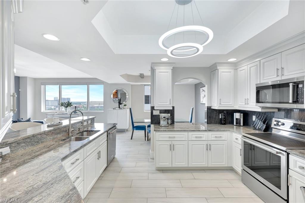 2104 West First Street, Unit 1404 Fort Myers, FL 33901 - Photo 9 of 33 a kitchen with stainless steel appliances a stove sink and cabinets