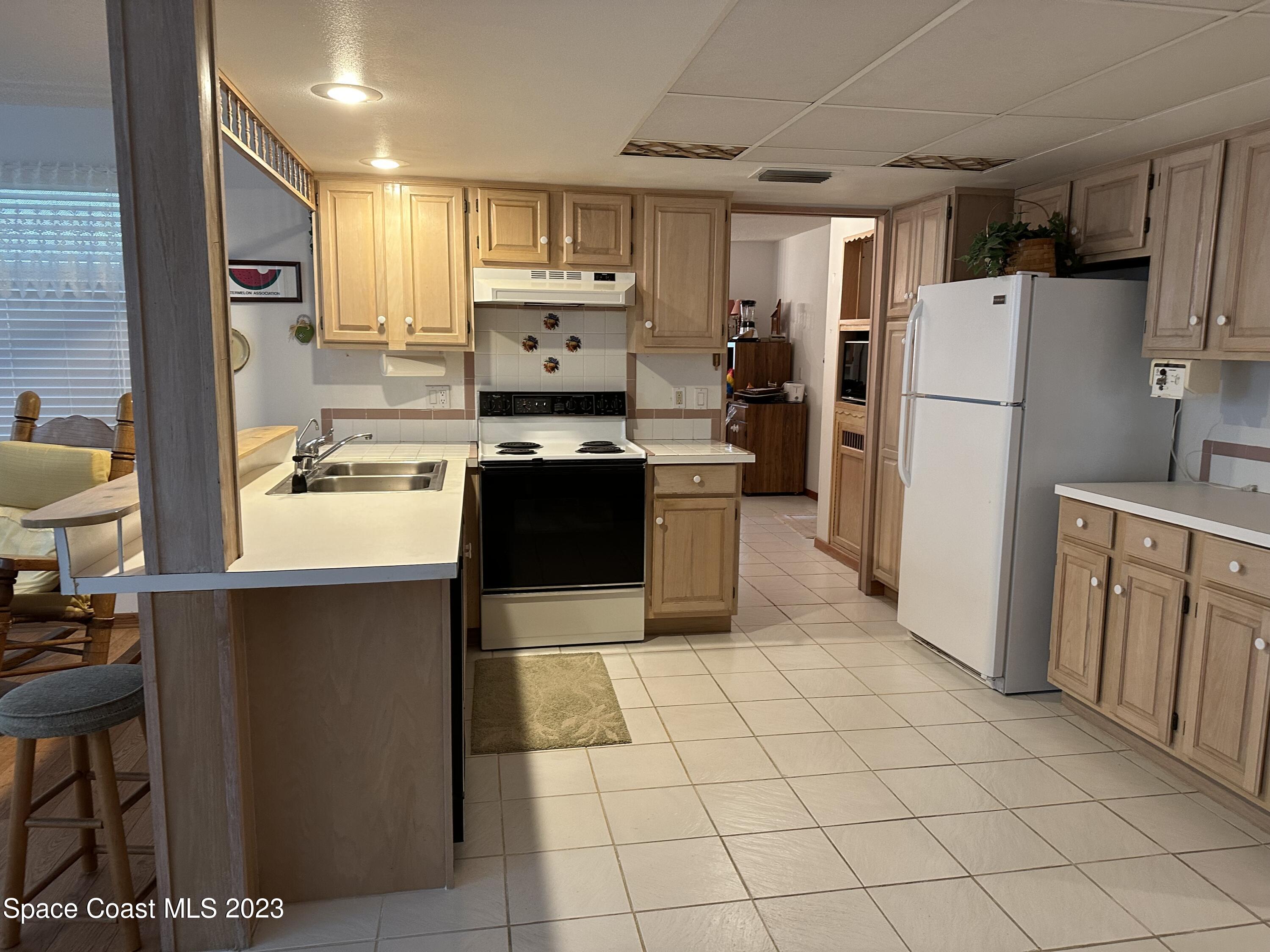 3995 Toby Avenue Malabar, FL 32950 - Photo 12 of 43 a kitchen with stainless steel appliances a refrigerator sink and cabinets