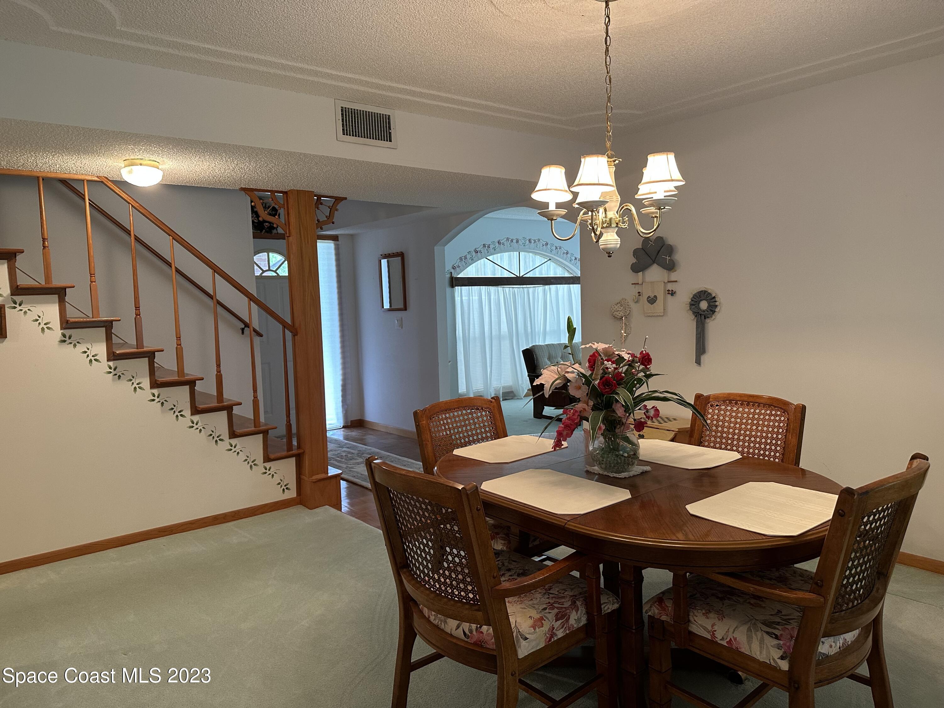 3995 Toby Avenue Malabar, FL 32950 - Photo 18 of 43 a view of a dining room with furniture and a chandelier