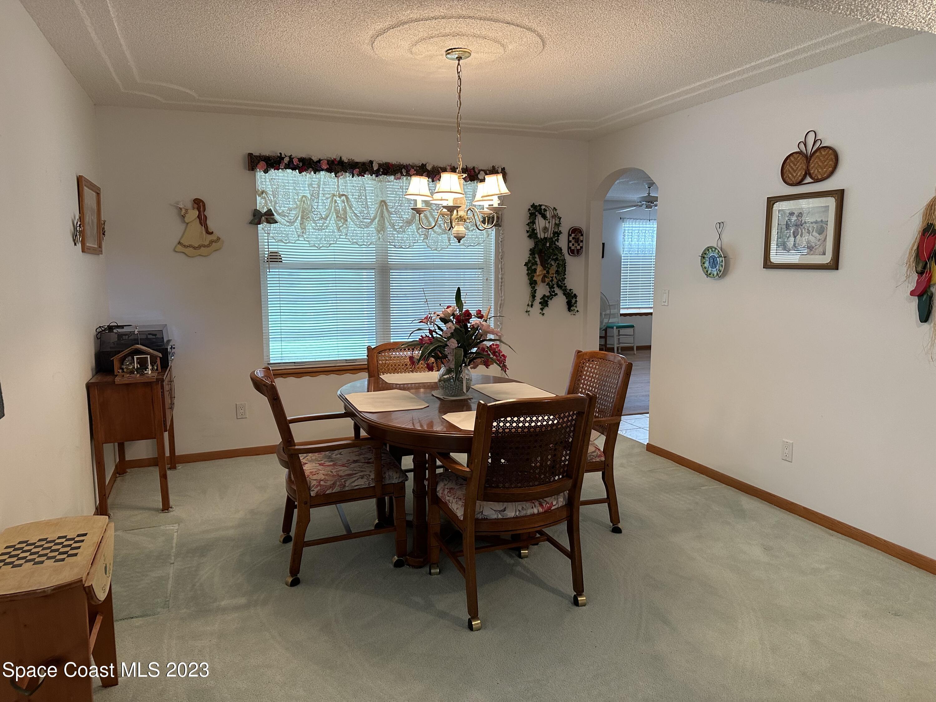 3995 Toby Avenue Malabar, FL 32950 - Photo 19 of 43 a dining room with furniture a chandelier and window