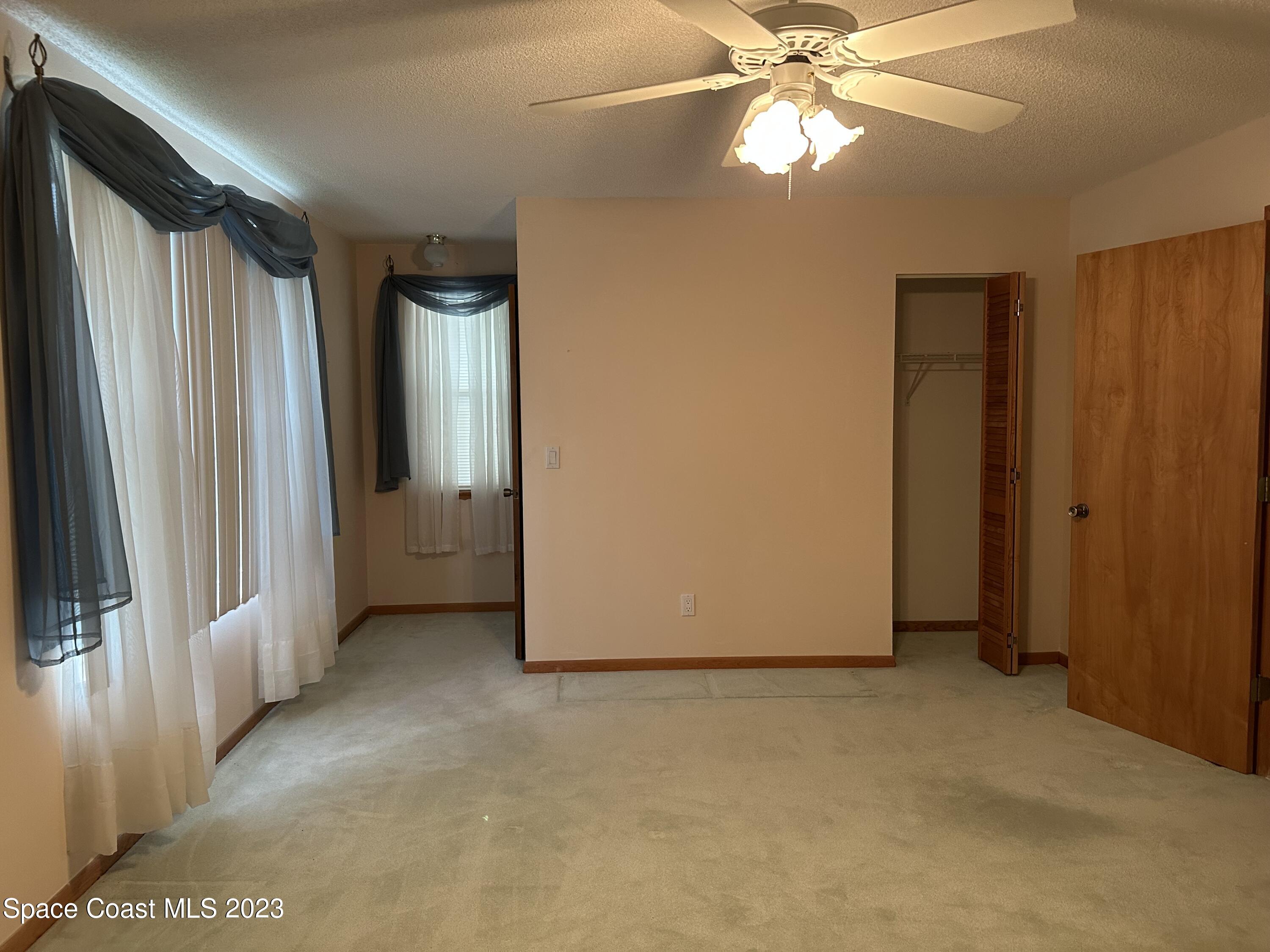 3995 Toby Avenue Malabar, FL 32950 - Photo 21 of 43 an empty room with windows and fan