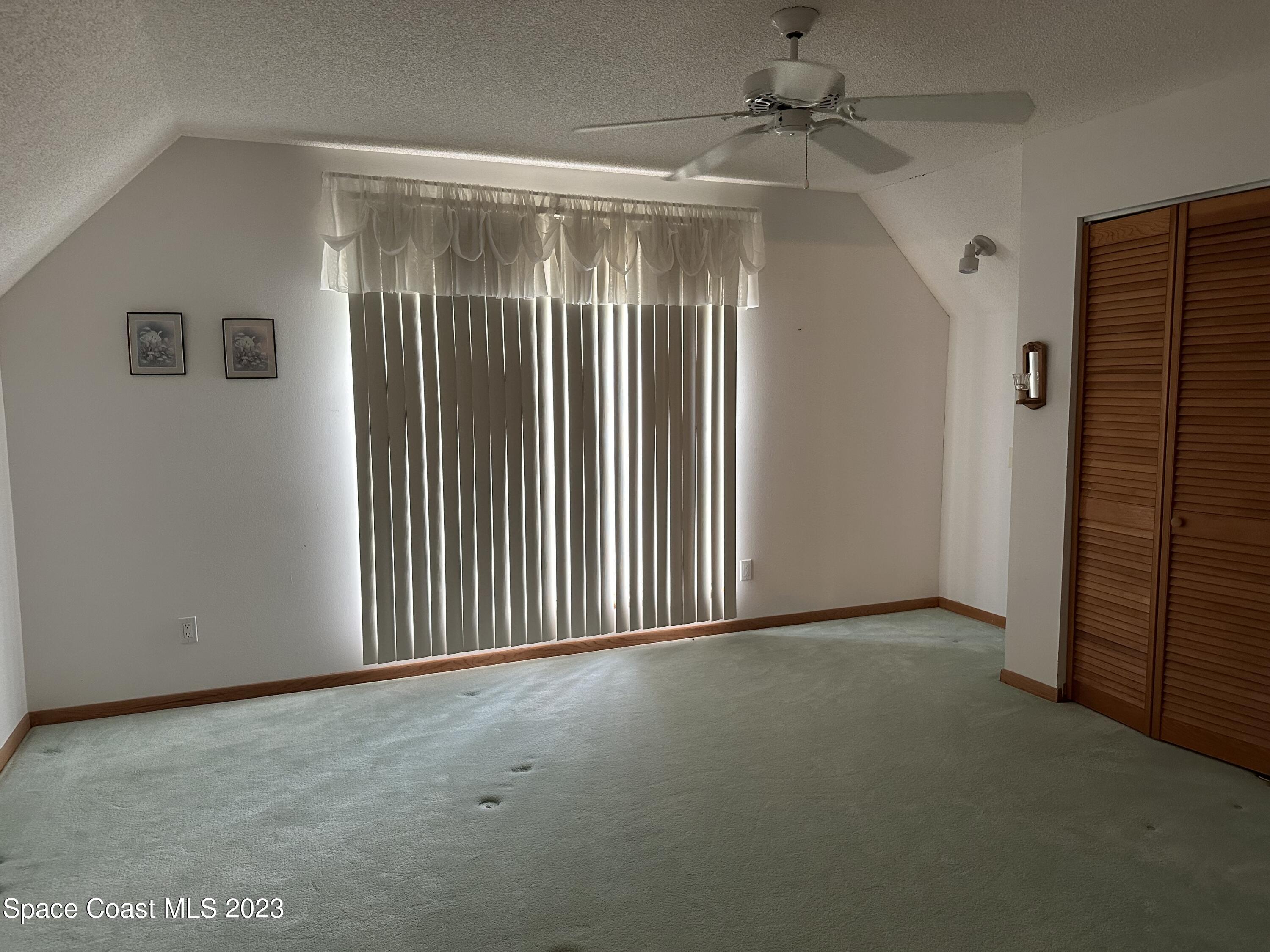 3995 Toby Avenue Malabar, FL 32950 - Photo 28 of 43 en empty room with windows and ceiling fan