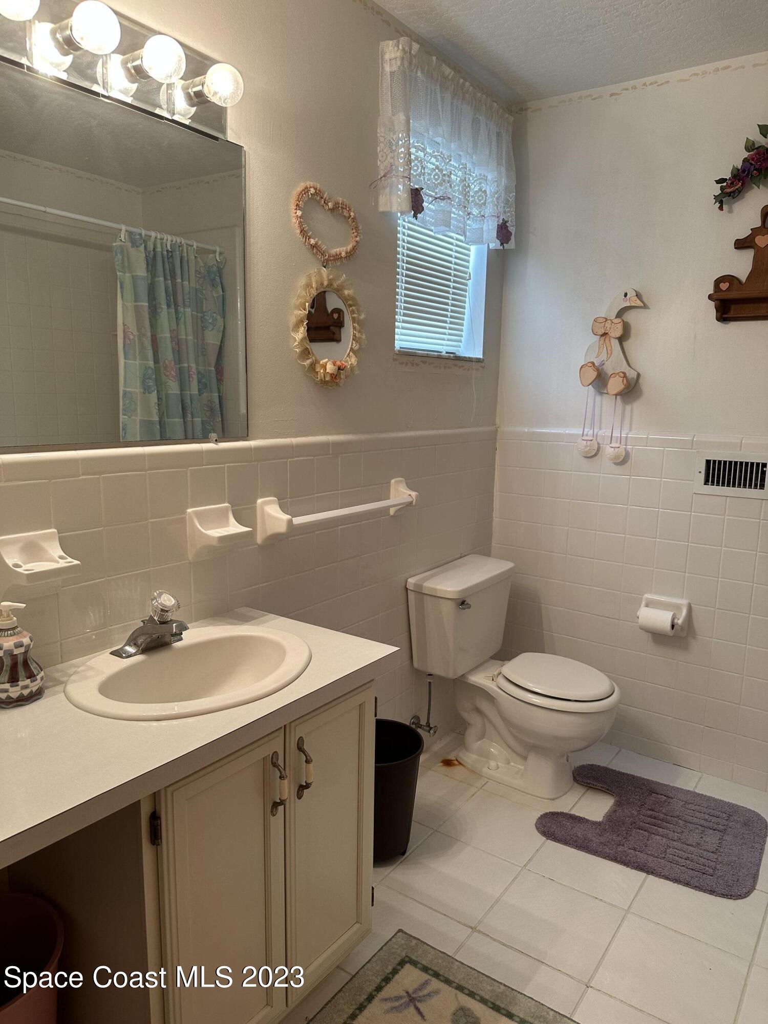 3995 Toby Avenue Malabar, FL 32950 - Photo 30 of 43 a bathroom with a toilet sink and mirror