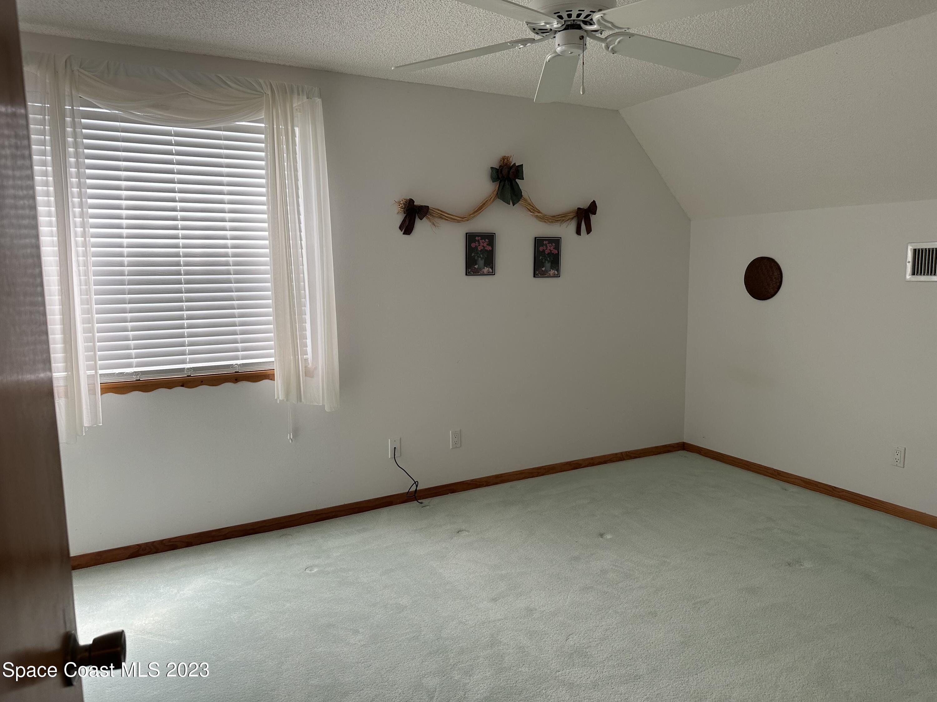 3995 Toby Avenue Malabar, FL 32950 - Photo 31 of 43 an empty room with a ceiling fan and a window