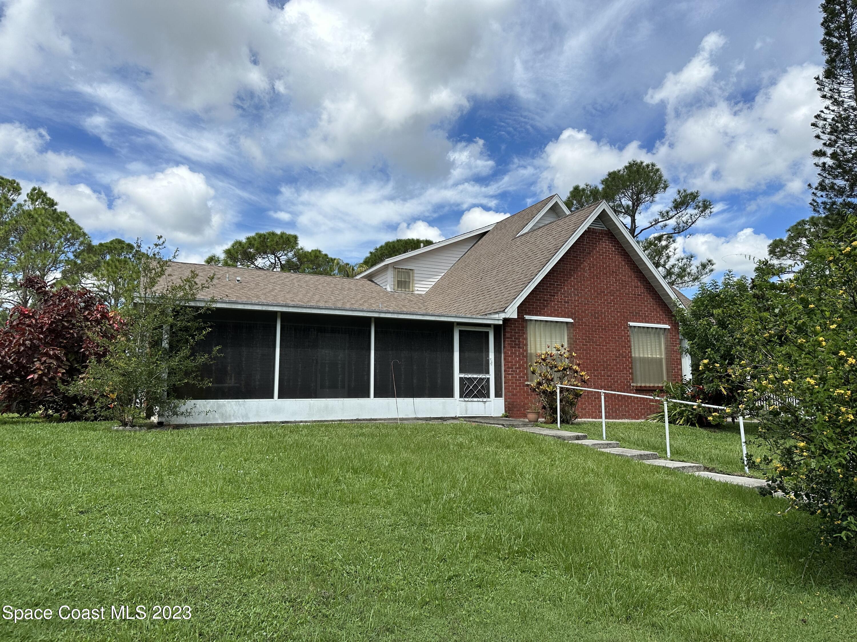 3995 Toby Avenue Malabar, FL 32950 - Photo 37 of 43 a view of a house with a yard and a large tree