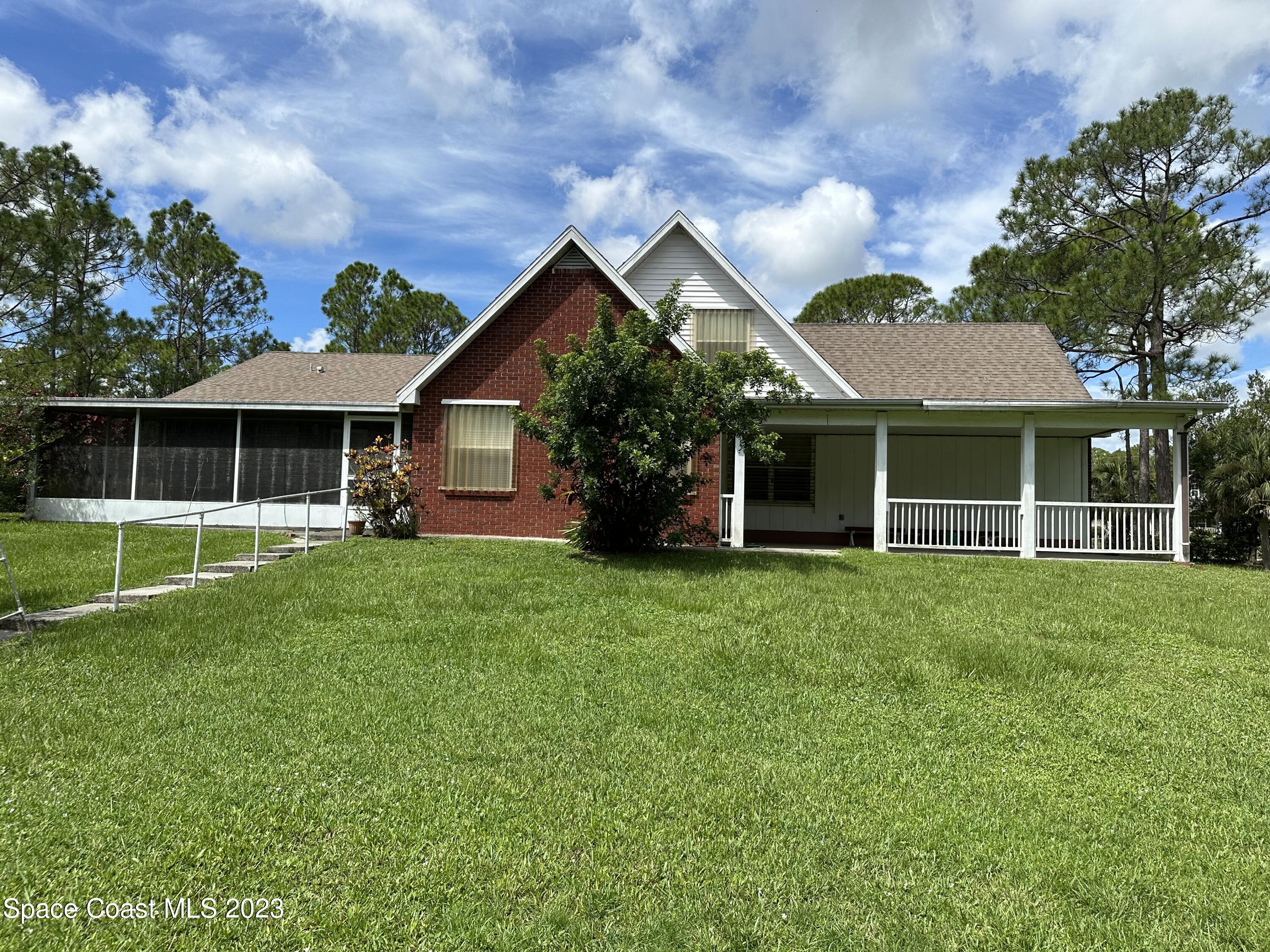 3995 Toby Avenue Malabar, FL 32950 - Photo 40 of 43 a front view of a house with a yard and porch