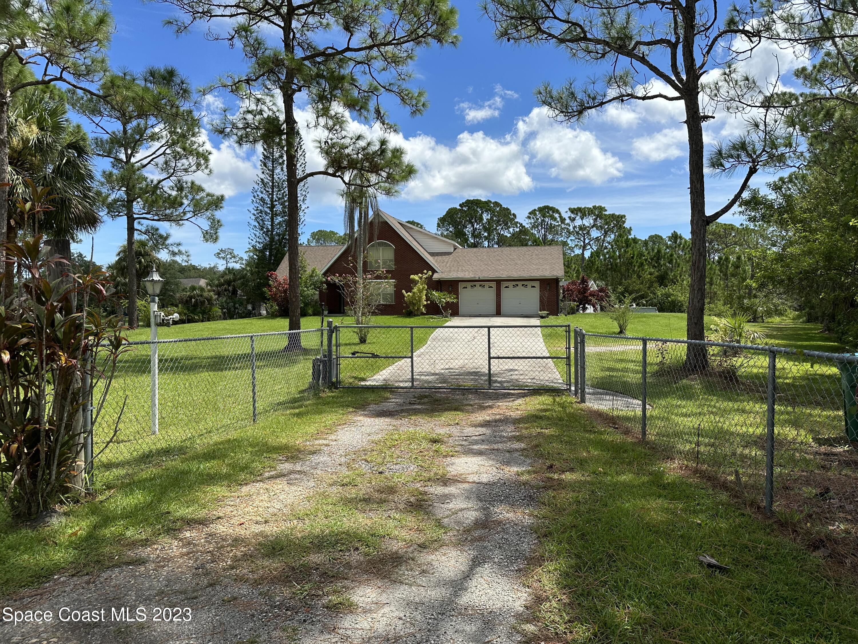 3995 Toby Avenue Malabar, FL 32950 - Photo 4 of 43 a view of a house with a backyard and a tree