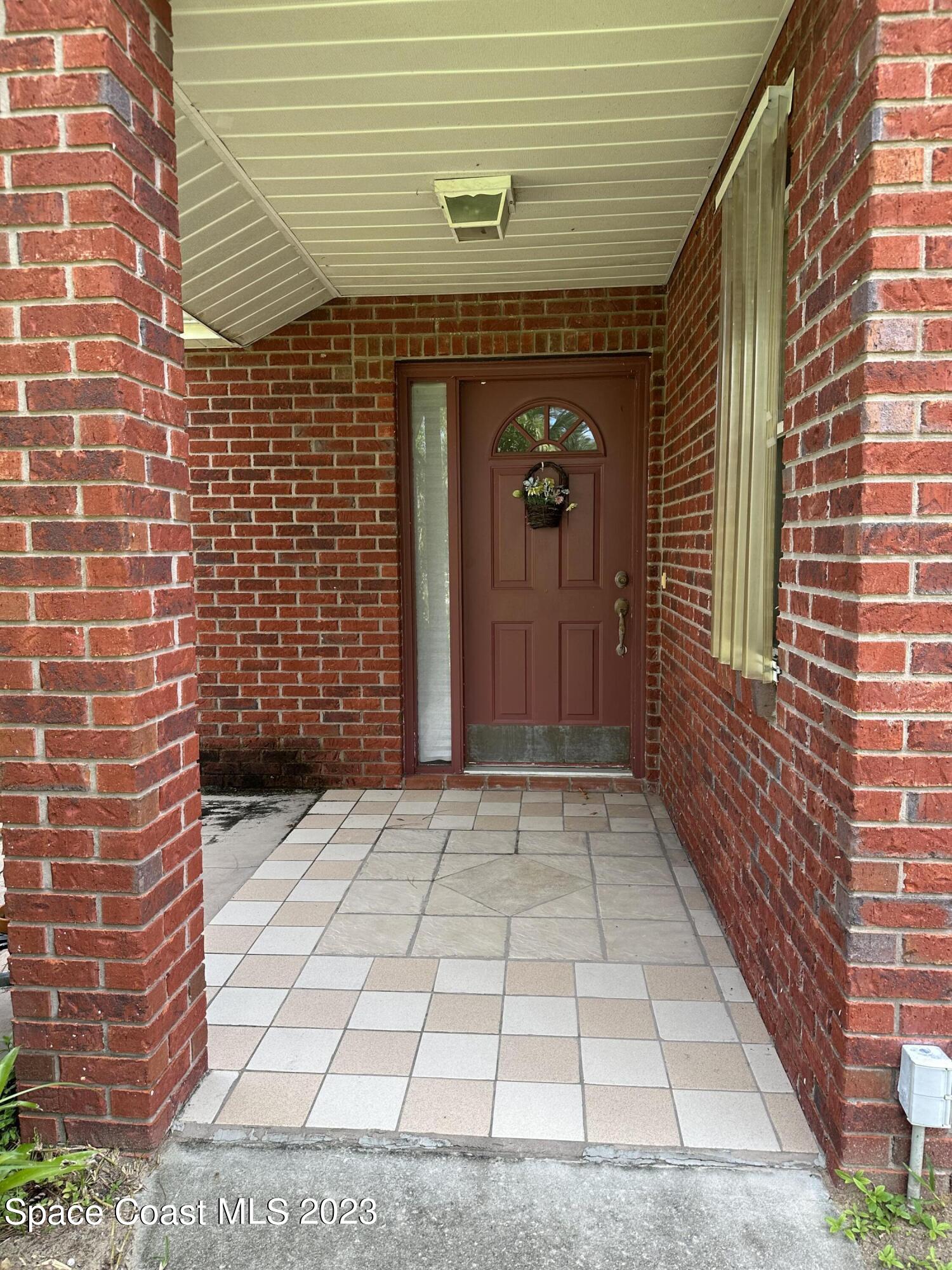 3995 Toby Avenue Malabar, FL 32950 - Photo 6 of 43 a view of a brick house with an empty space