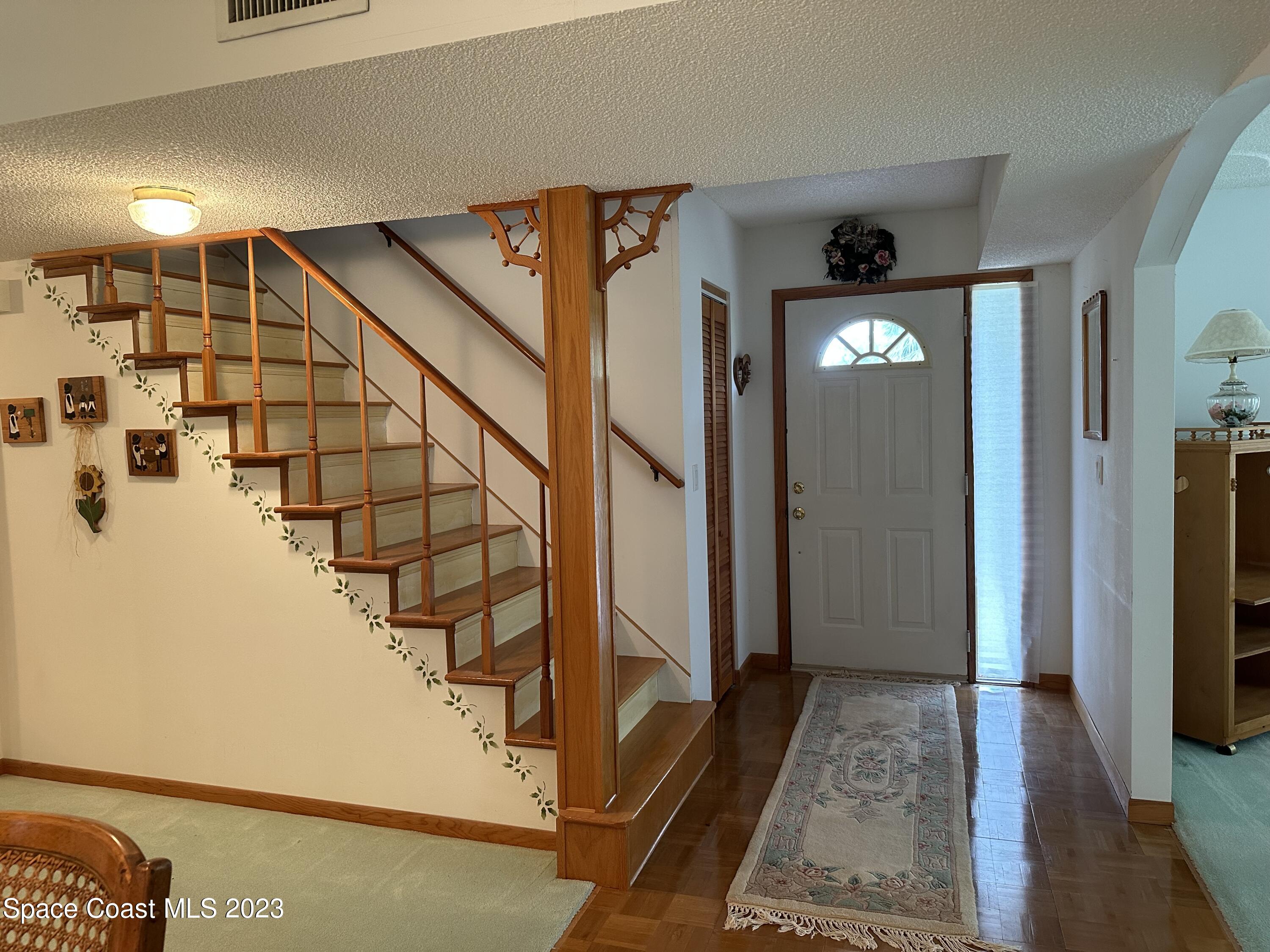 3995 Toby Avenue Malabar, FL 32950 - Photo 7 of 43 a view of a hallway with wooden floor and staircase