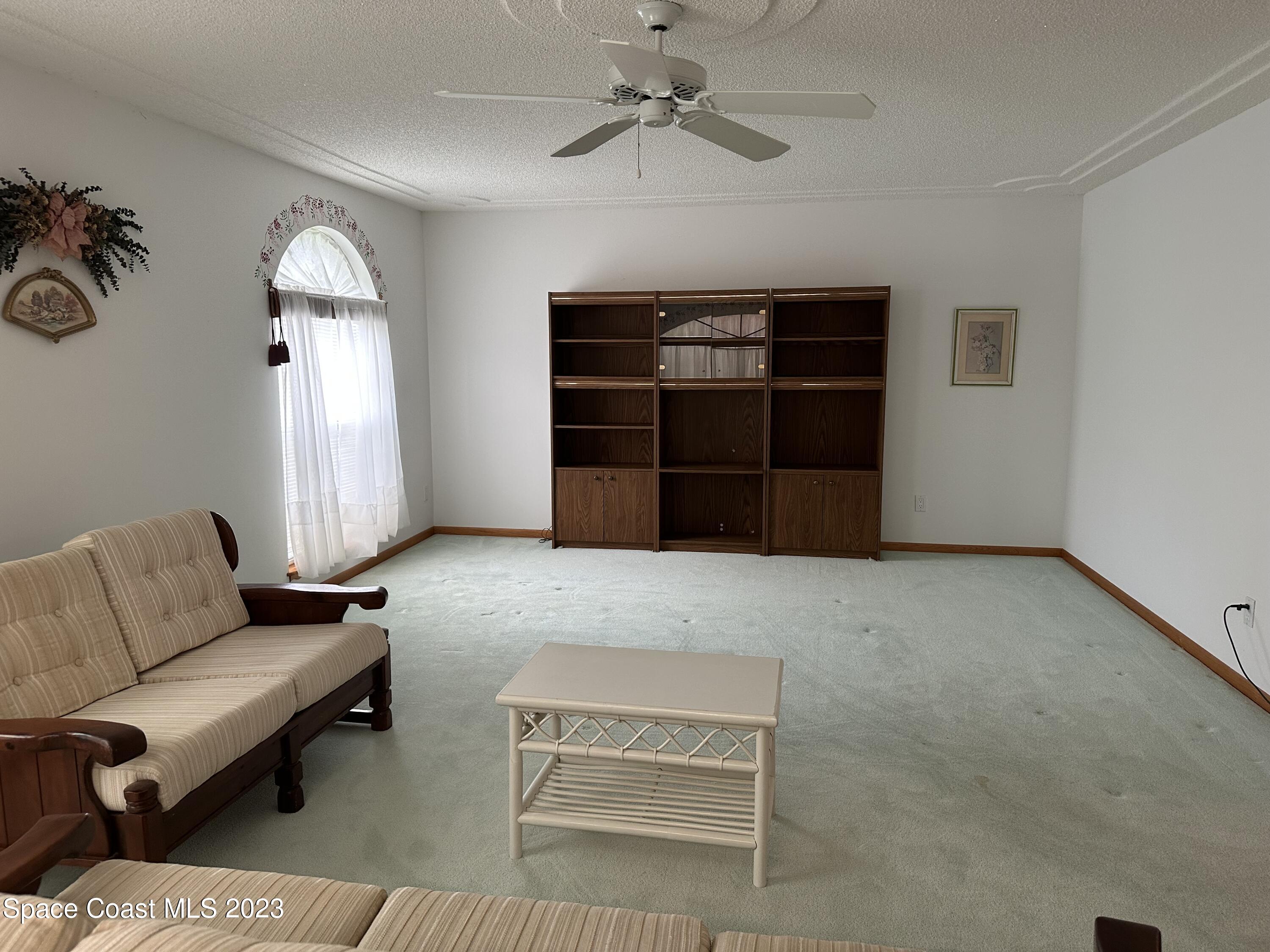 3995 Toby Avenue Malabar, FL 32950 - Photo 9 of 43 a living room with furniture and a ceiling fan