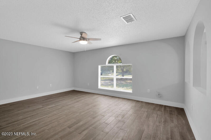 692 Largo Lane Macclenny, FL 32063 - Photo 18 of 41 an empty room with wooden floor and windows