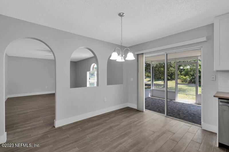 692 Largo Lane Macclenny, FL 32063 - Photo 29 of 41 a view of a room with wooden floor chandeliers and kitchen view