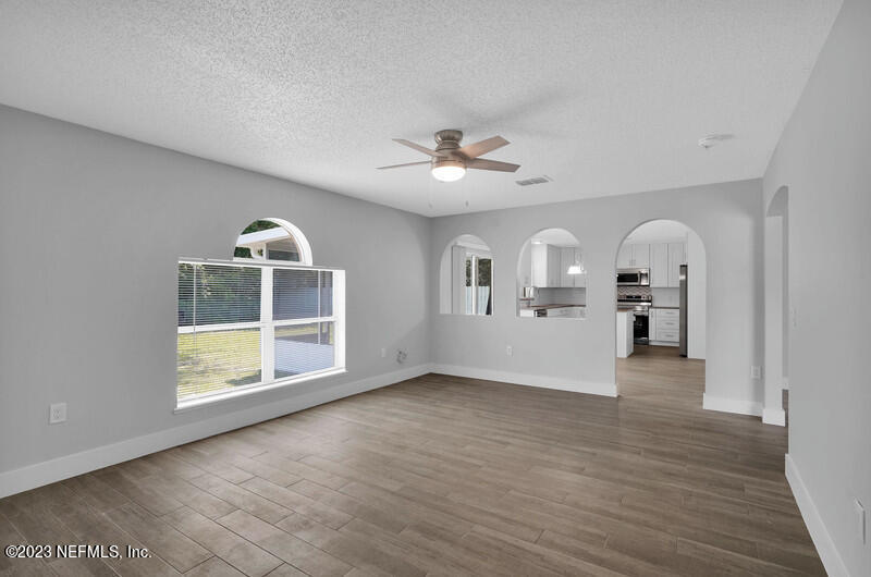 692 Largo Lane Macclenny, FL 32063 - Photo 30 of 41 an empty room with chandelier fan and wooden floor