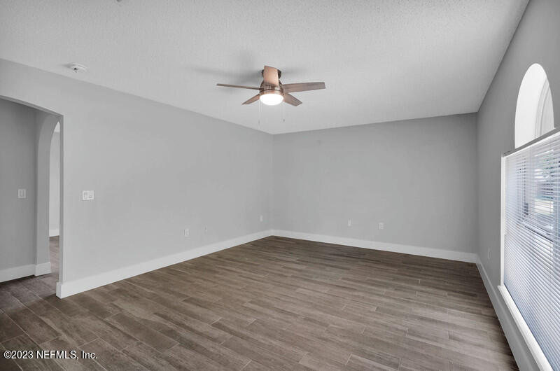 692 Largo Lane Macclenny, FL 32063 - Photo 32 of 41 an empty room with wooden floor ceiling fan and windows