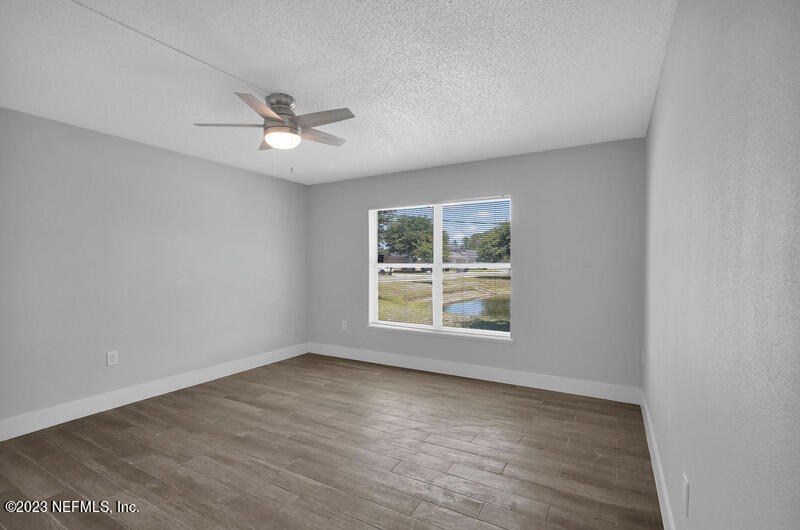 692 Largo Lane Macclenny, FL 32063 - Photo 37 of 41 an empty room with wooden floor ceiling fan and windows