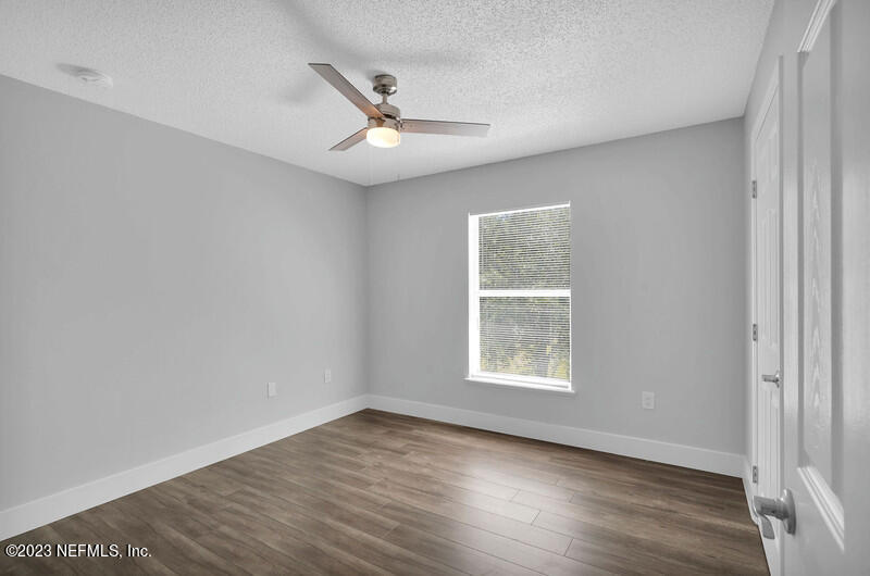 692 Largo Lane Macclenny, FL 32063 - Photo 40 of 41 an empty room with wooden floor fan and windows