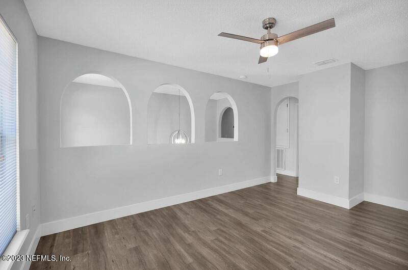 692 Largo Lane Macclenny, FL 32063 - Photo 41 of 41 an empty room with wooden floor fan and windows