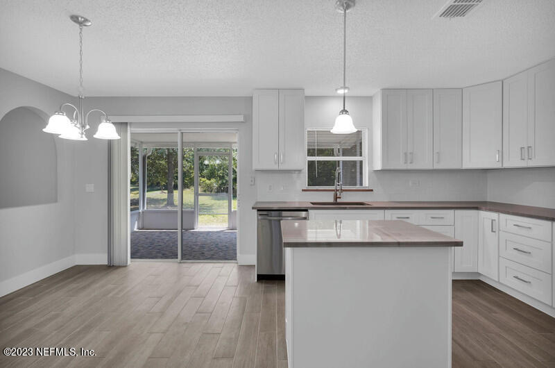692 Largo Lane Macclenny, FL 32063 - Photo 7 of 41 a kitchen with stainless steel appliances granite countertop a stove a sink dishwasher and a refrigerator with wooden floor