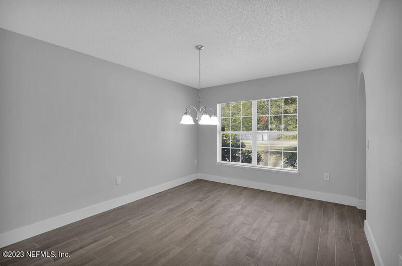 692 Largo Lane Macclenny, FL 32063 - Photo 9 of 41 an empty room with wooden floor and windows
