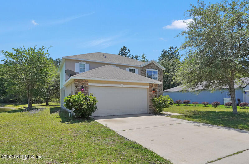 692 Largo Lane Macclenny, FL 32063 - Photo 10 of 41 a front view of a house with a yard and garage
