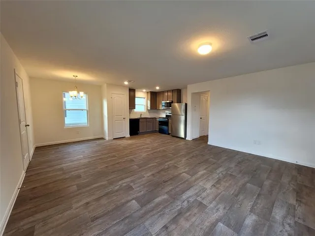 a view of empty room with a kitchen