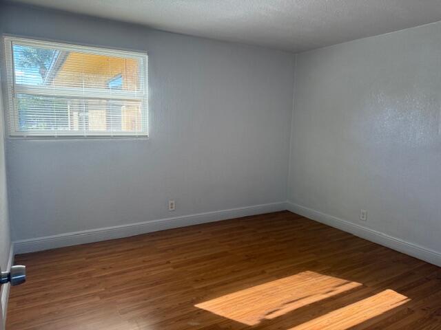 2840 Avenue S A Riviera Beach, Unit 3 Riviera Beach, FL 33404 - Photo 17 of 23 a view of an empty room with wooden floor and a window