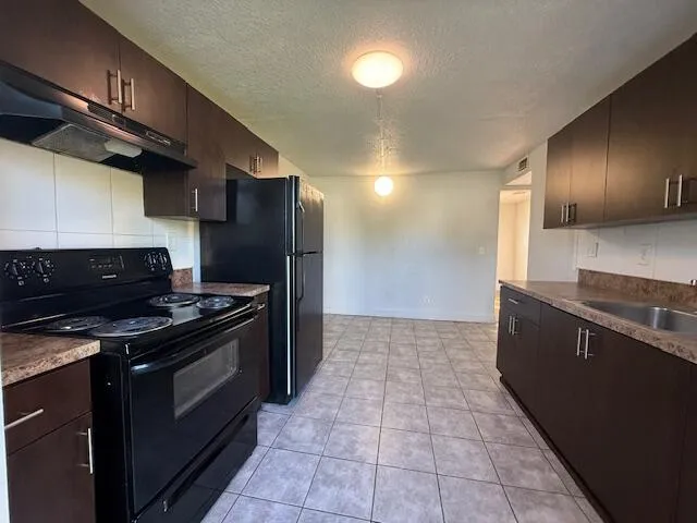 a kitchen with granite countertop a stove and a sink
