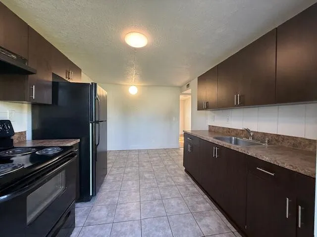 a kitchen with stainless steel appliances granite countertop a refrigerator and a stove