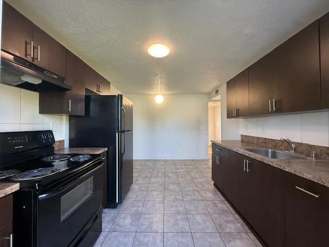a kitchen with granite countertop a stove and a refrigerator