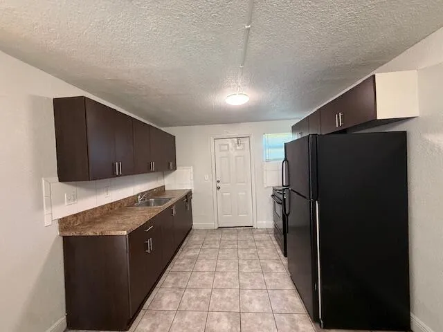 a large kitchen with a stove a refrigerator and a oven