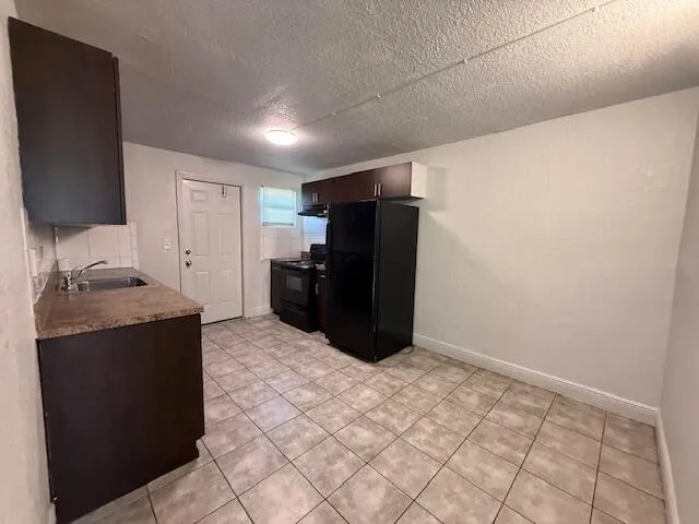 a kitchen with granite countertop a refrigerator and a stove