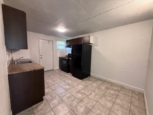 2840 Avenue S A Riviera Beach, Unit 3 Riviera Beach, FL 33404 - Photo 9 of 23 a kitchen with granite countertop a refrigerator and a stove