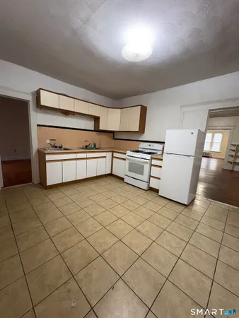 a kitchen with stainless steel appliances cabinets and front door
