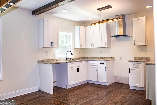 a kitchen with granite countertop wooden cabinets and white appliances