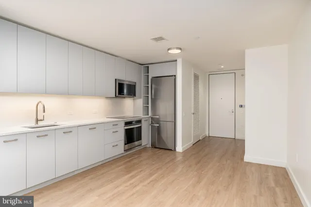 a kitchen with granite countertop a sink stove and refrigerator