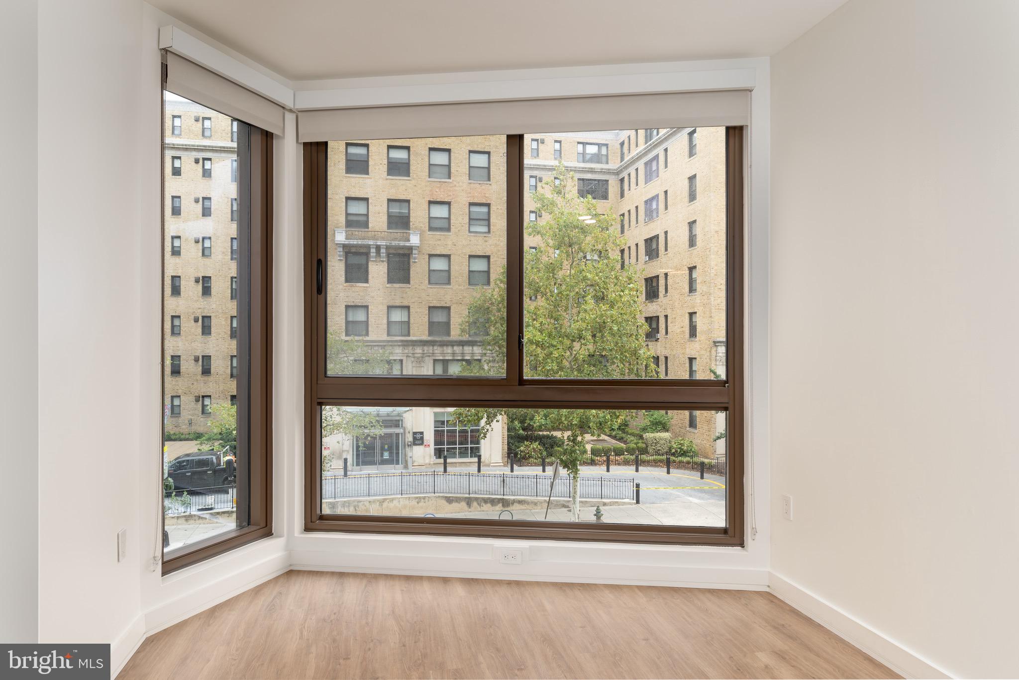 1630 Columbia Road Northwest, Unit 316 Washington, DC 20009 - Photo 4 of 20 an empty room with wooden floor and windows