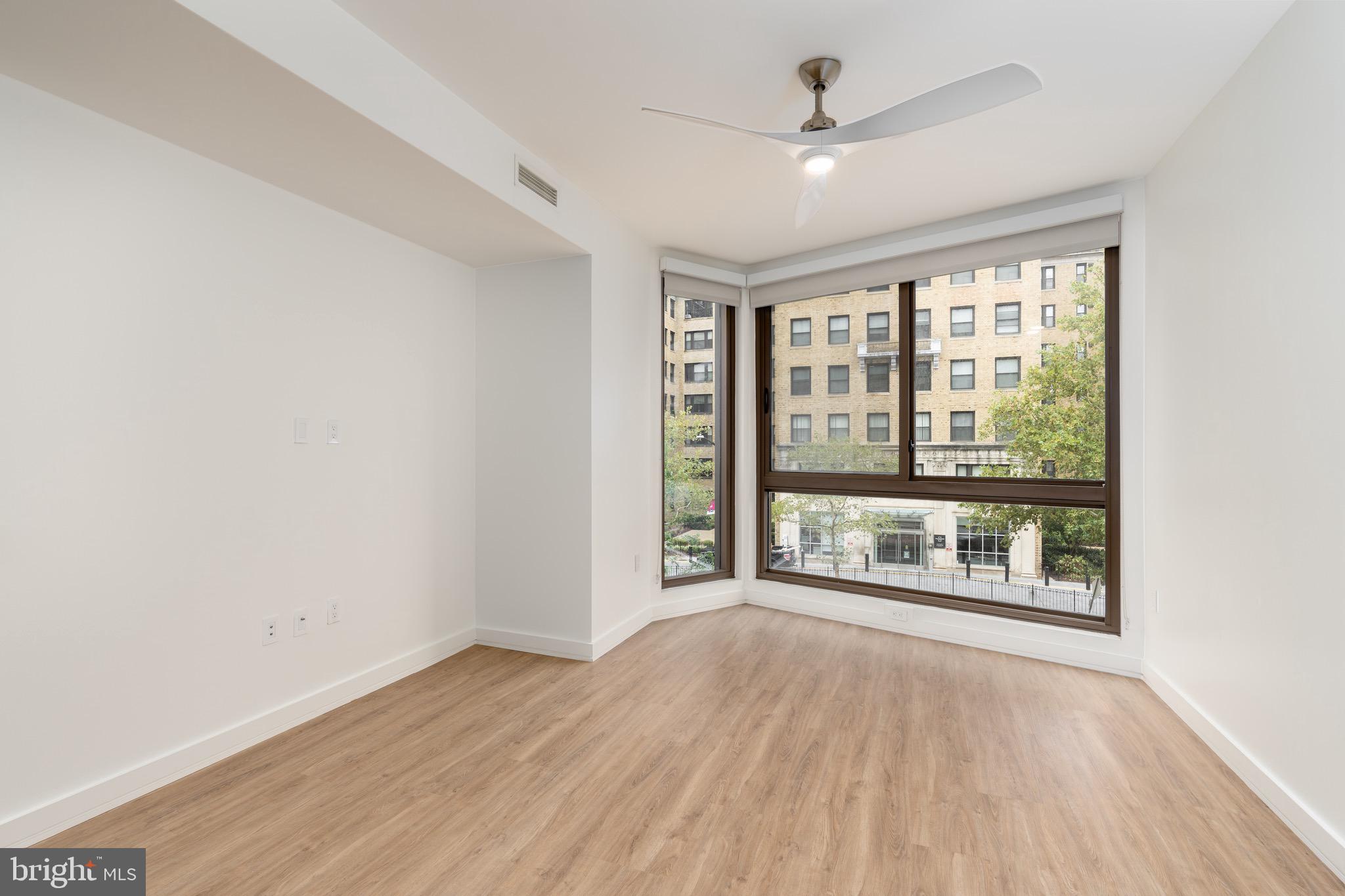 1630 Columbia Road Northwest, Unit 316 Washington, DC 20009 - Photo 5 of 20 an empty room with wooden floor and windows