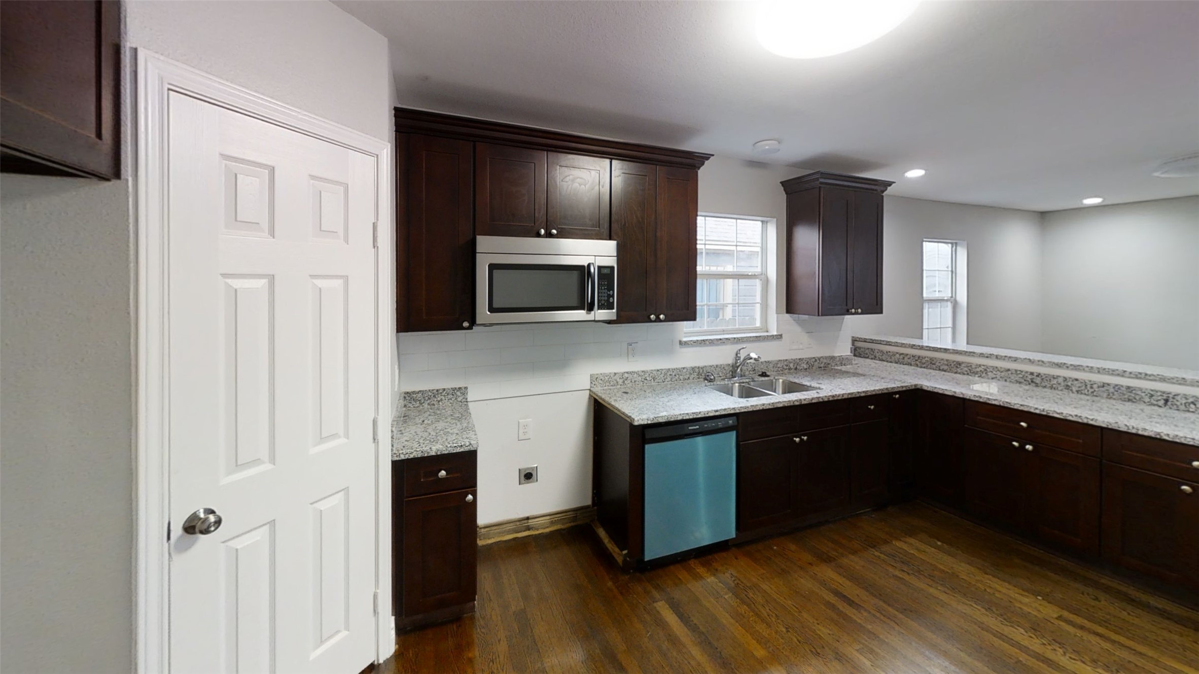 a large kitchen with stainless steel appliances granite countertop a sink and cabinets