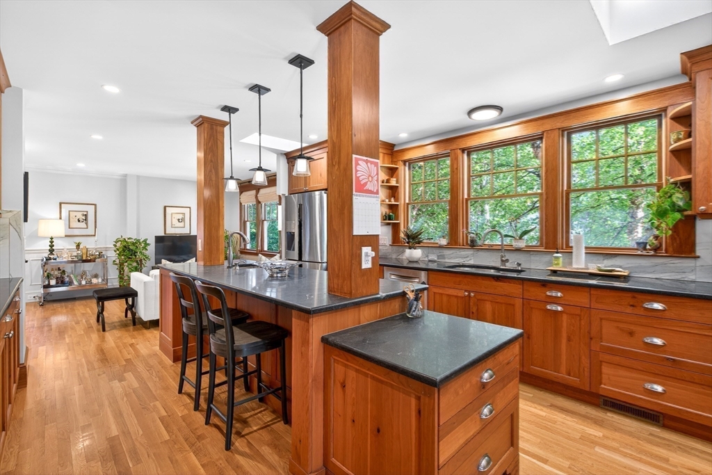 76-78 Lewis Road Belmont, MA 02478 - Photo 19 of 36 a kitchen with stainless steel appliances granite countertop a stove top oven and a dining table with wooden floor