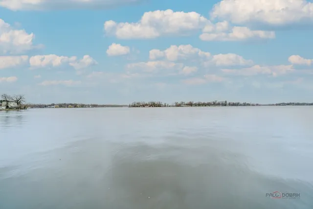 a view of a white house next to a road and yard