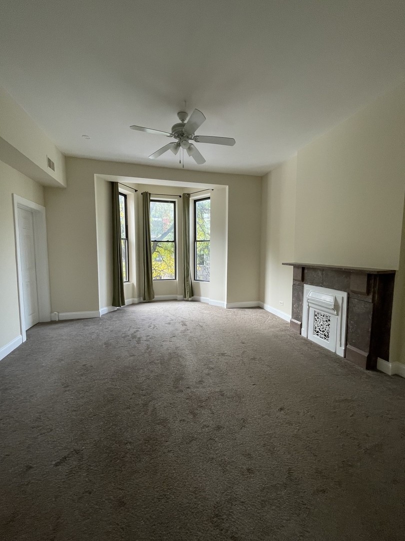 733 North Wells Street, Unit 2 Chicago, IL 60654 - Photo 2 of 12 a view of a big room with windows and chandelier fan