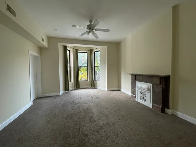 a view of an empty room with a fireplace and a window