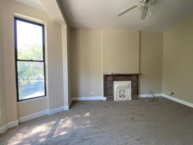a view of an empty room with a fireplace and a window