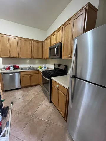 a kitchen with stainless steel appliances a refrigerator a sink a stove a microwave and cabinets