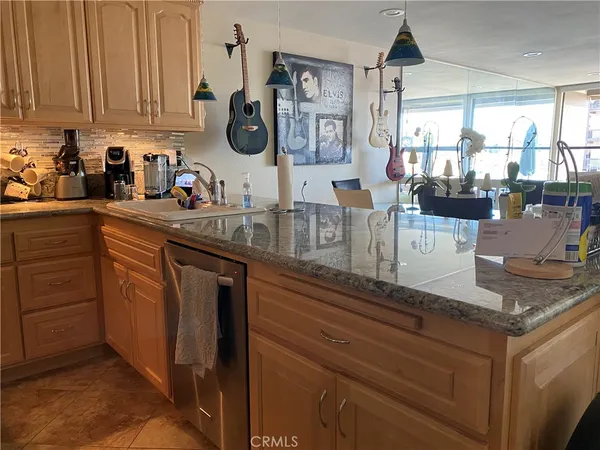 a kitchen with stainless steel appliances granite countertop a sink a stove and a wooden cabinets