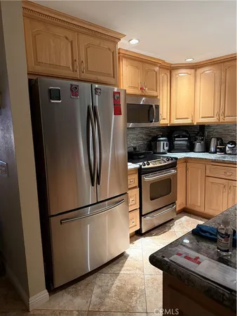 a kitchen with stainless steel appliances granite countertop a refrigerator stove and sink