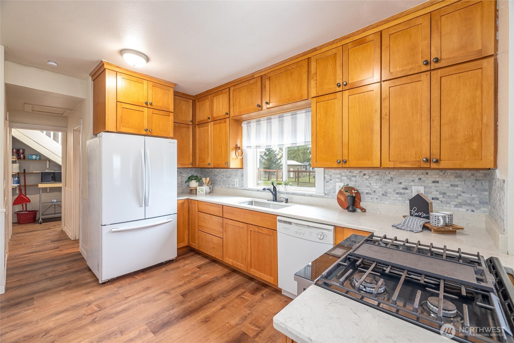 812 Sumas Avenue Sumas, WA 98295 - Photo 11 of 24 a kitchen with stainless steel appliances granite countertop a refrigerator a sink dishwasher a stove with white cabinets and wooden floor