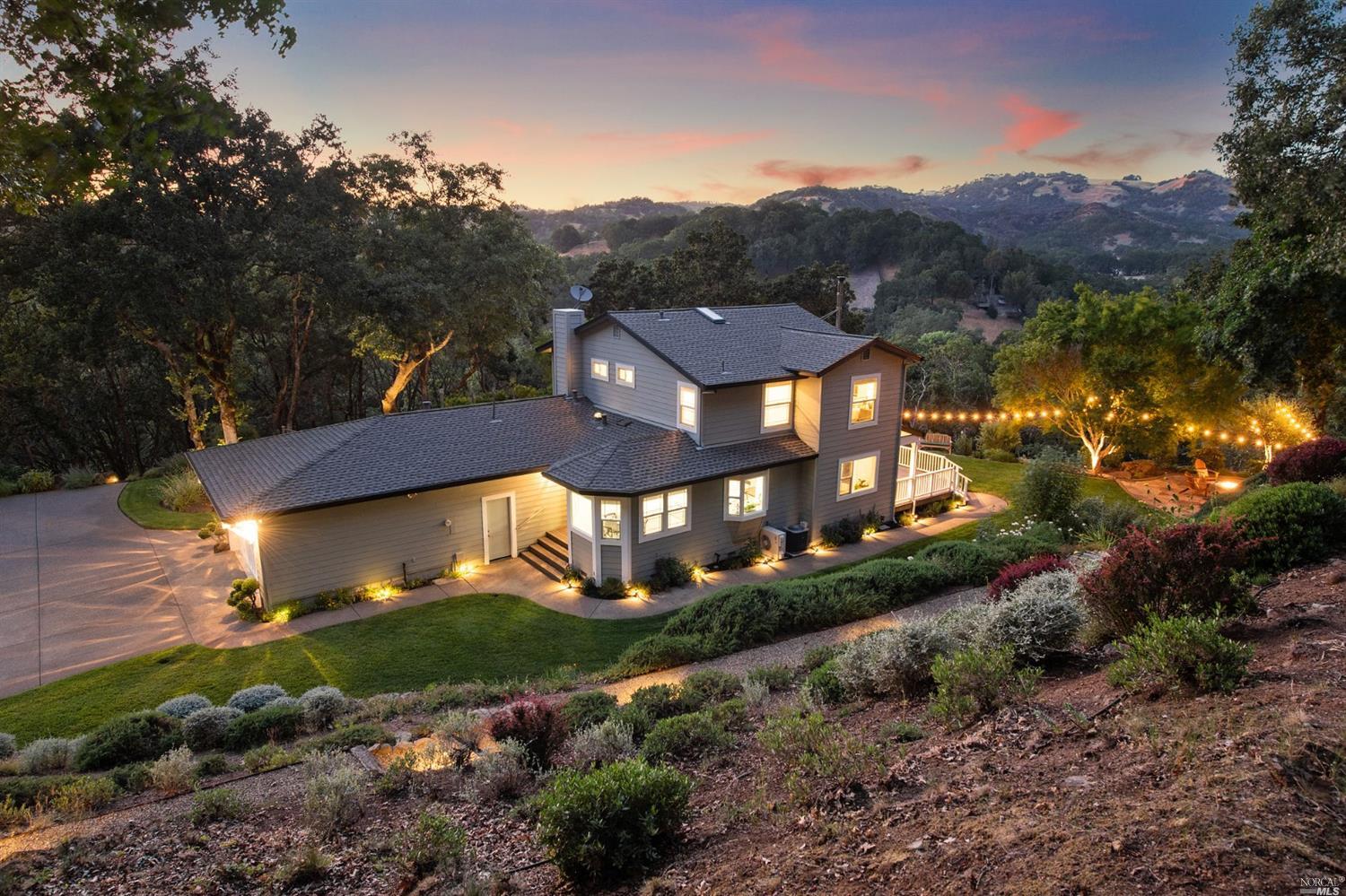 a view of a house with a big yard and large trees